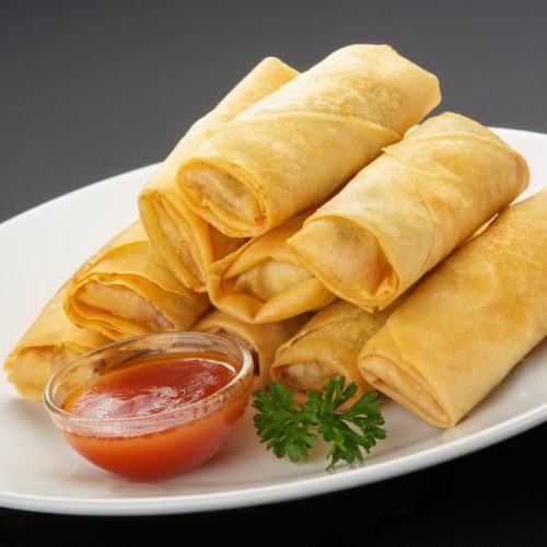 Spring rolls platter with 12 - 24 mini golden vegetable and chicken spring rolls arranged on a round tray, ready to serve.